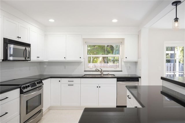 kitchen featuring sink, decorative light fixtures, white cabinetry, and appliances with stainless steel finishes