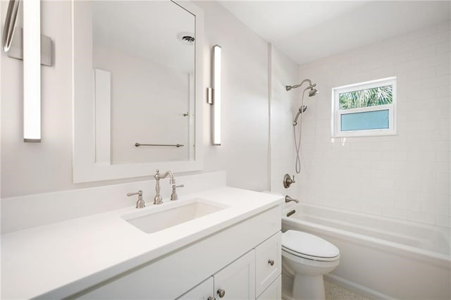 full bathroom with toilet, vanity, and tiled shower / bath