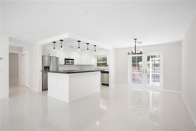 kitchen with decorative light fixtures, white cabinetry, a notable chandelier, a kitchen island, and stainless steel appliances