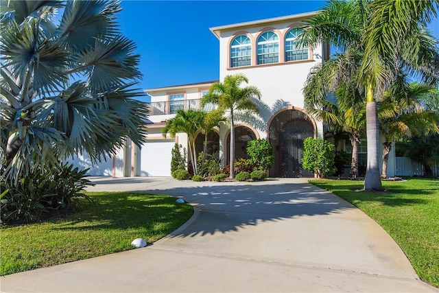 mediterranean / spanish-style home featuring a balcony, a front lawn, and a garage