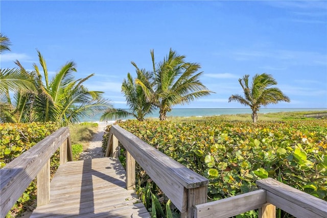 view of property's community with a water view and a beach view