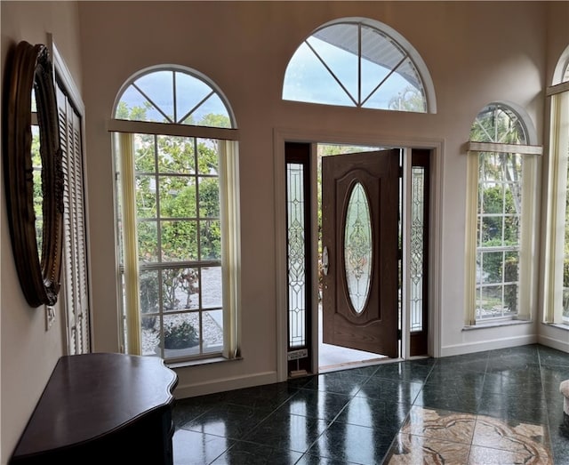 entrance foyer featuring a high ceiling, granite finish floor, and baseboards