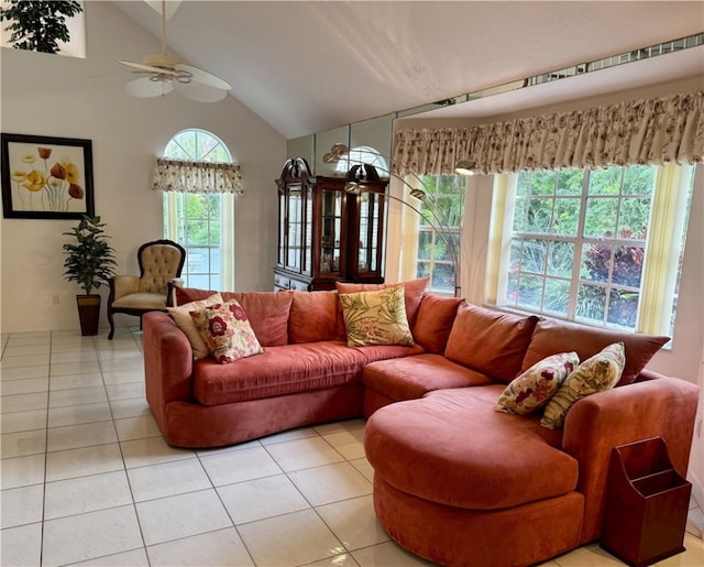 living area with light tile patterned floors, high vaulted ceiling, and a ceiling fan