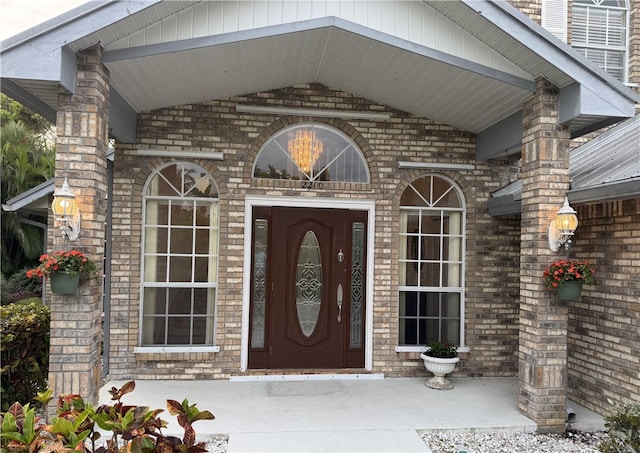 doorway to property featuring brick siding