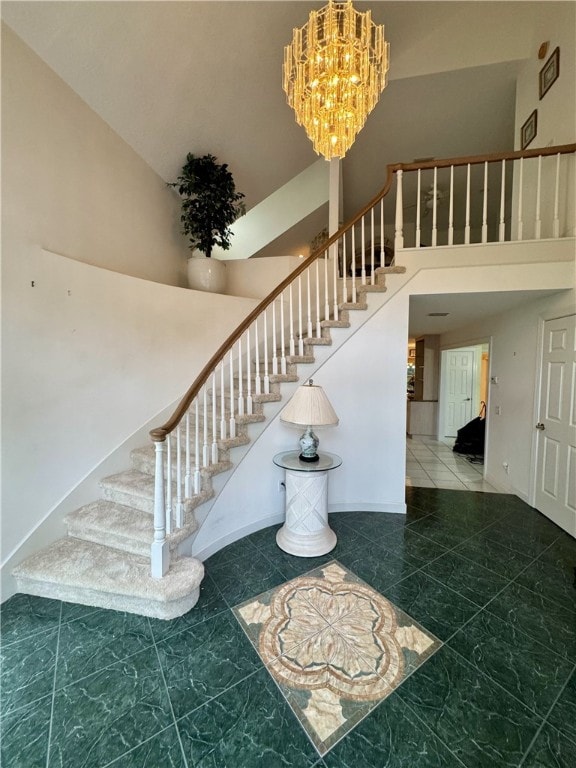 stairs with a towering ceiling, baseboards, and an inviting chandelier