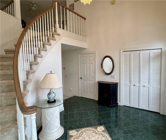 foyer with stairs, a high ceiling, and baseboards