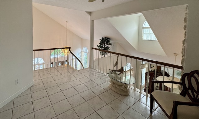 unfurnished room with high vaulted ceiling, a wealth of natural light, and tile patterned floors