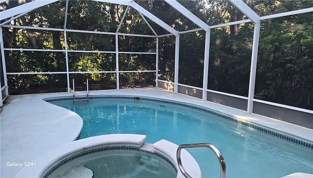 view of pool featuring a lanai and an in ground hot tub