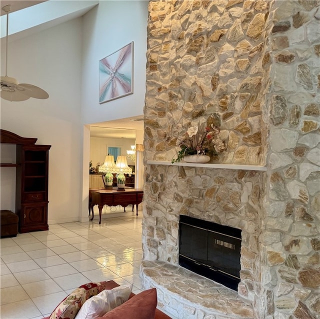 living room featuring a fireplace, a ceiling fan, and tile patterned floors