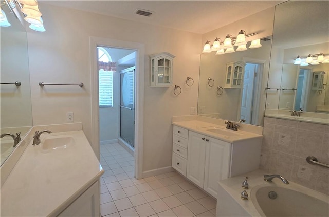 full bathroom with two vanities, a stall shower, visible vents, and a sink