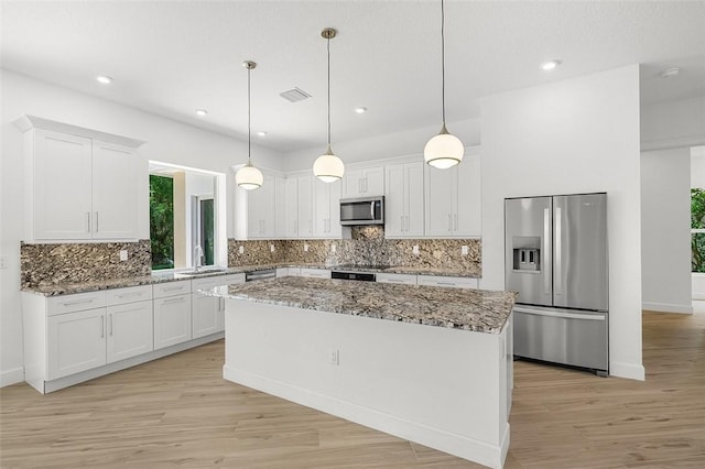 1090 Buckhead Dr SW, Vero Beach, FL 32968 - kitchen featuring appliances with stainless steel finishes, a center island, white cabinets, and recessed lighting