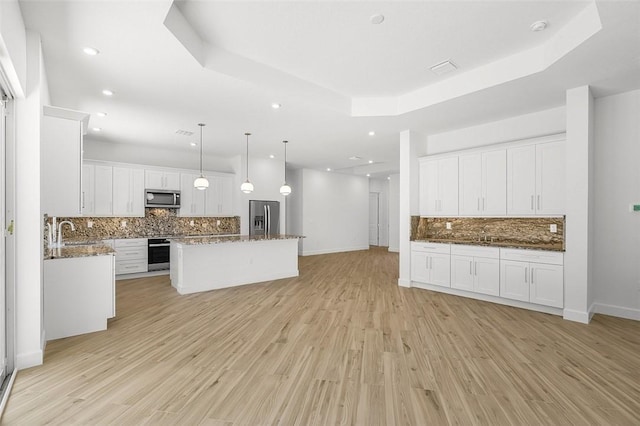1090 Buckhead Dr SW, Vero Beach, FL 32968 - kitchen with stainless steel appliances, a sink, tasteful backsplash, open floor plan, and a tray ceiling