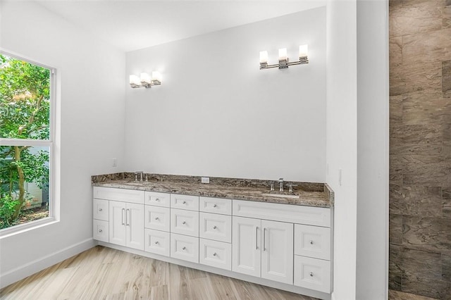 1090 Buckhead Dr SW, Vero Beach, FL 32968 - bathroom featuring double vanity, wood finished floors, and baseboards
