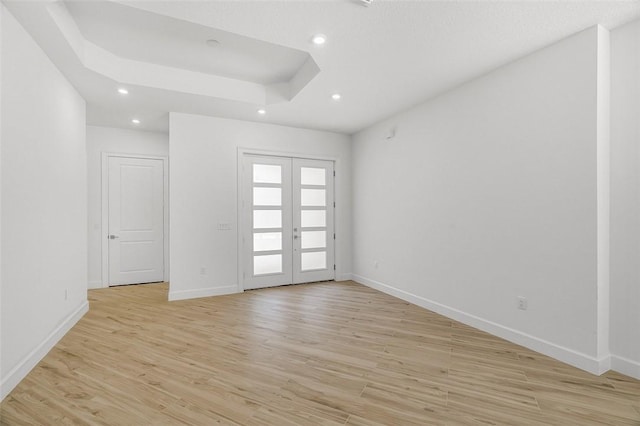 1090 Buckhead Dr SW, Vero Beach, FL 32968 - empty room featuring french doors, baseboards, light wood-style flooring, recessed lighting, and a raised ceiling
