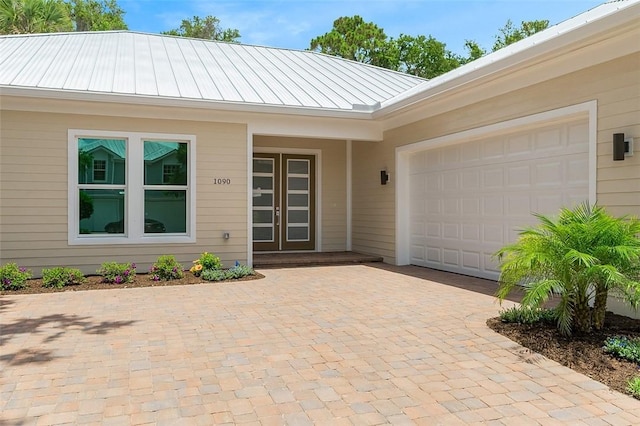 1090 Buckhead Dr SW, Vero Beach, FL 32968 - entrance to property featuring decorative driveway, a standing seam roof, metal roof, and an attached garage