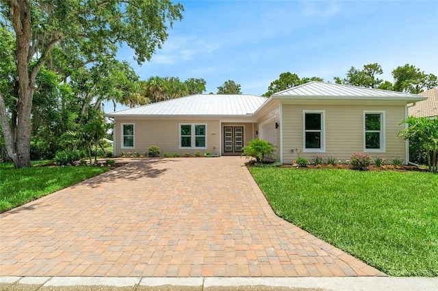 1090 Buckhead Dr SW, Vero Beach, FL 32968 - ranch-style home featuring a front lawn, a standing seam roof, metal roof, and decorative driveway