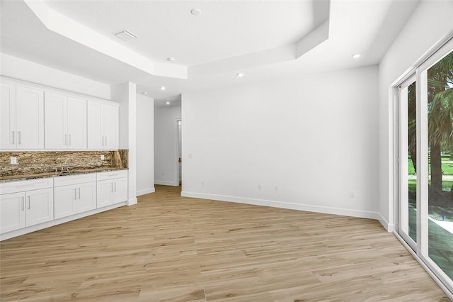 1090 Buckhead Dr SW, Vero Beach, FL 32968 - kitchen featuring a raised ceiling, plenty of natural light, white cabinets, and recessed lighting