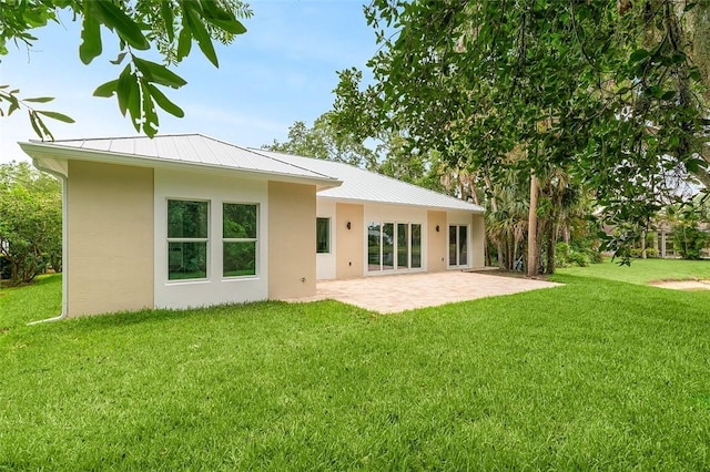 1090 Buckhead Dr SW, Vero Beach, FL 32968 - back of property featuring stucco siding, a patio, a yard, and metal roof