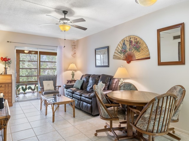 living room featuring a textured ceiling, light tile patterned floors, and ceiling fan