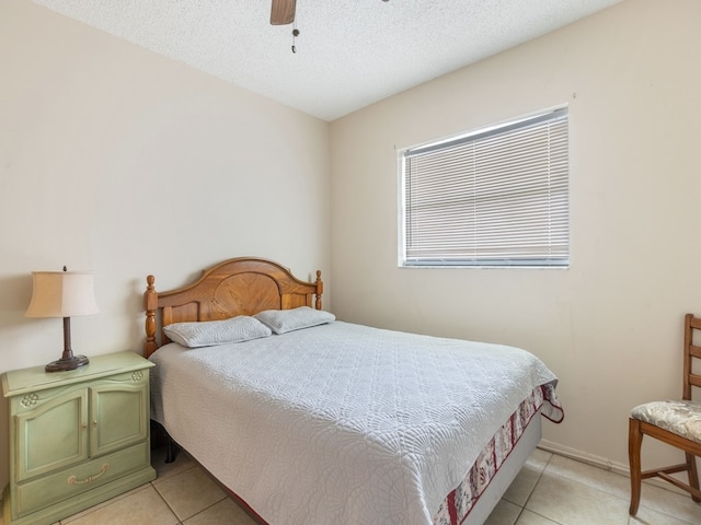 bedroom featuring a textured ceiling, ceiling fan, and light tile patterned floors