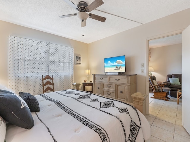 tiled bedroom with a textured ceiling and ceiling fan