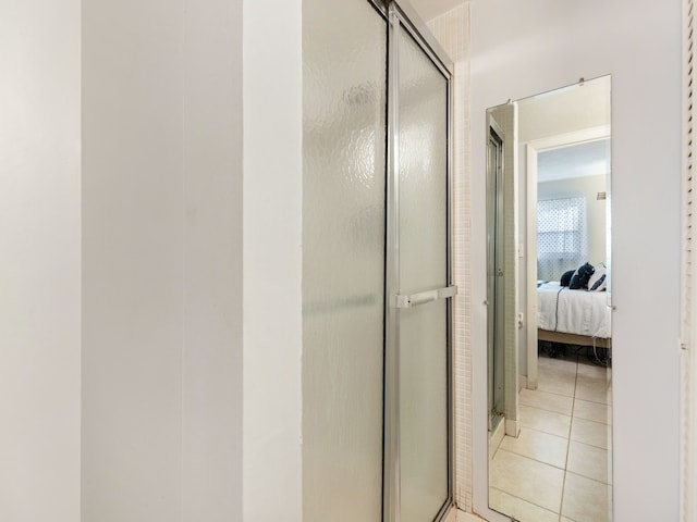 bathroom with tile patterned floors and a shower with shower door