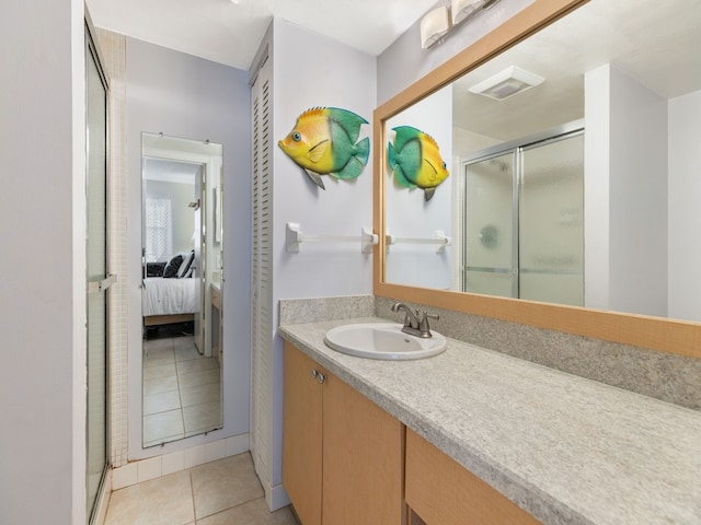 bathroom with vanity, a shower with door, and tile patterned flooring