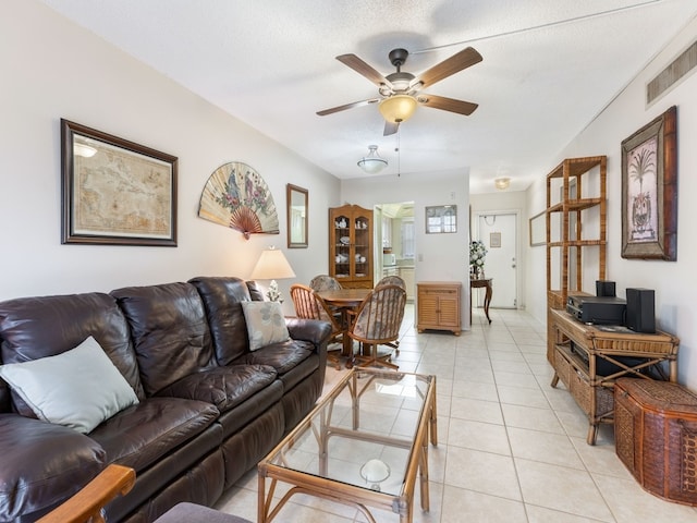 tiled living room with a textured ceiling and ceiling fan