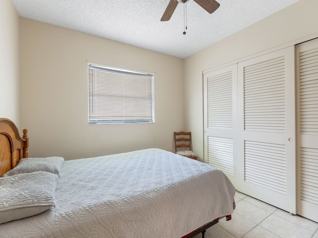 tiled bedroom featuring a closet, a textured ceiling, and ceiling fan