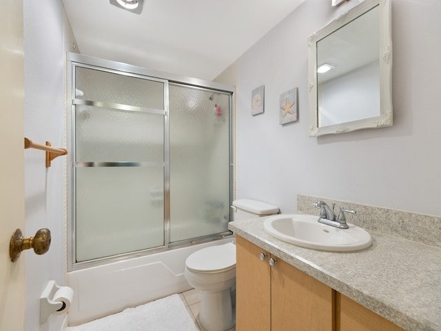 full bathroom featuring bath / shower combo with glass door, tile patterned flooring, vanity, and toilet