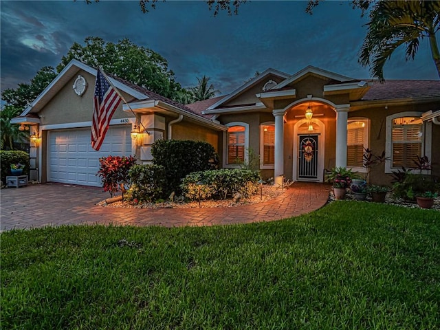 view of front of home with a garage and a yard