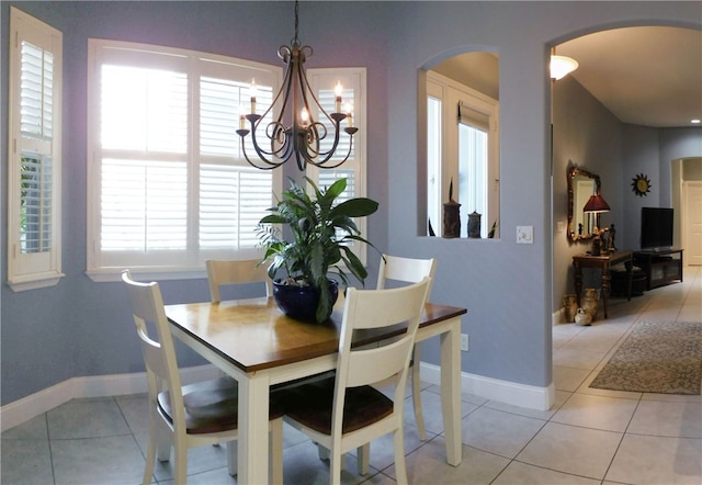 dining area featuring a wealth of natural light, a notable chandelier, and light tile patterned floors