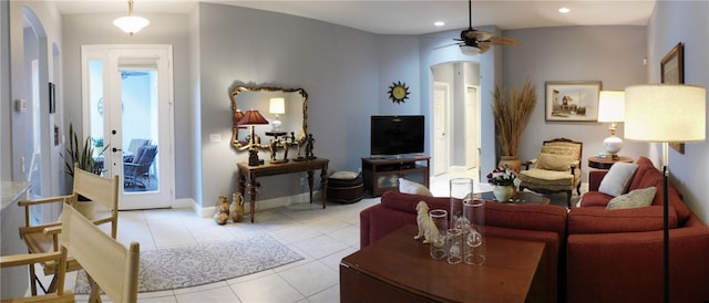 living room featuring a healthy amount of sunlight, lofted ceiling, ceiling fan, and light tile patterned flooring