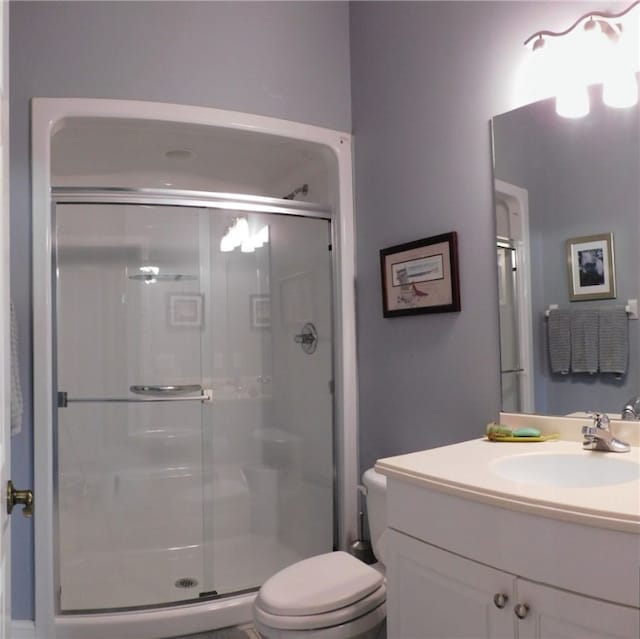 bathroom featuring walk in shower, vanity, and toilet