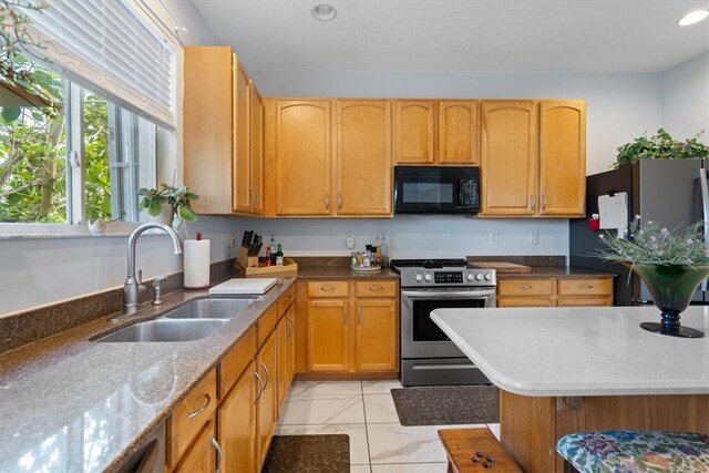 kitchen featuring light stone countertops, sink, and appliances with stainless steel finishes