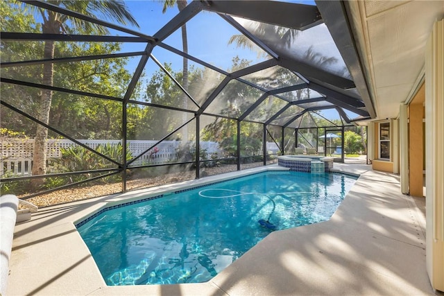 view of pool with a patio area, a pool with connected hot tub, and glass enclosure