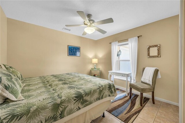 bedroom with a ceiling fan, light tile patterned flooring, visible vents, and baseboards