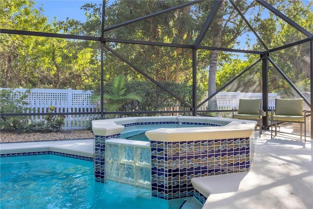 outdoor pool with glass enclosure, a patio area, and an in ground hot tub