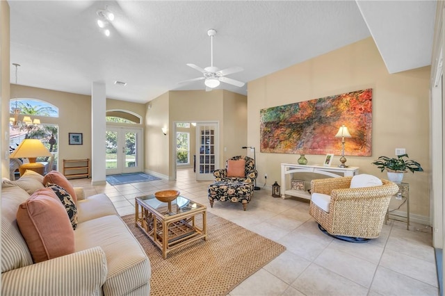 living room featuring french doors, light tile patterned flooring, ceiling fan, and baseboards