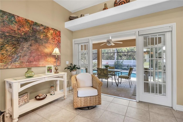 living area featuring ceiling fan, light tile patterned flooring, and baseboards