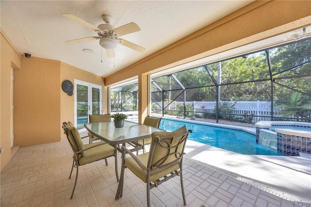 interior space featuring ceiling fan, a lanai, fence, outdoor dining area, and a pool with connected hot tub