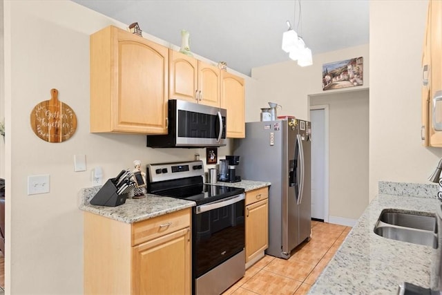 kitchen featuring sink, light stone countertops, light tile patterned floors, light brown cabinetry, and stainless steel appliances