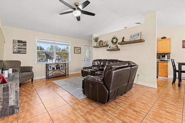 living room with ceiling fan, lofted ceiling, and light tile patterned flooring