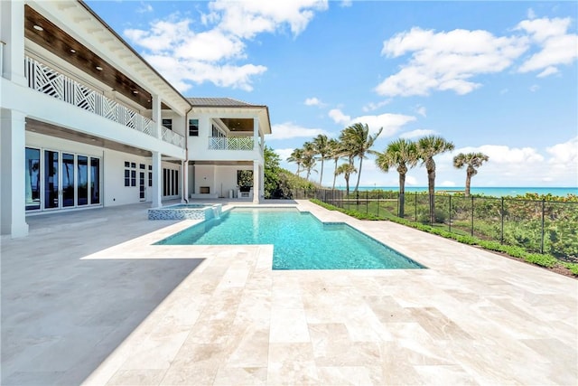 330 N Blue Wave Ln, Vero Beach, FL 32963 - view of swimming pool with a pool with connected hot tub, a patio, a water view, and fence