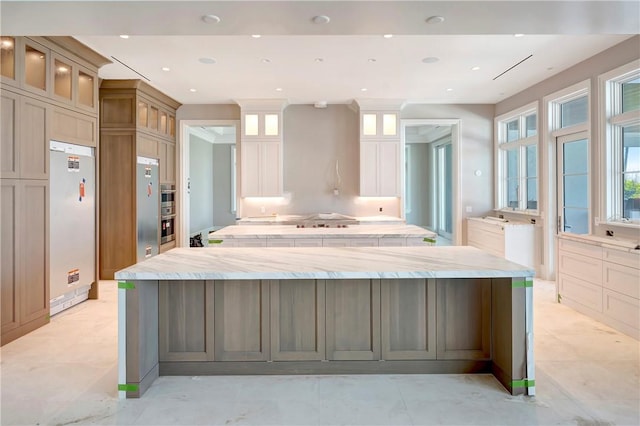 330 N Blue Wave Ln, Vero Beach, FL 32963 - kitchen featuring fridge, a spacious island, glass insert cabinets, and recessed lighting