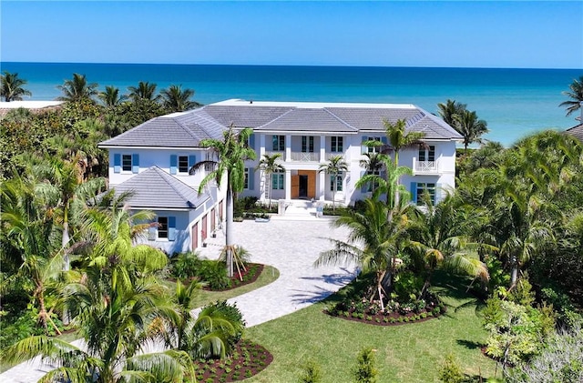 330 N Blue Wave Ln, Vero Beach, FL 32963 - view of front of home with a balcony, driveway, stucco siding, a front lawn, and a water view