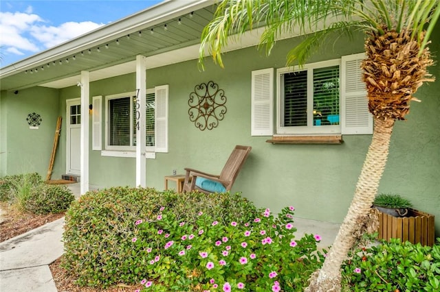 view of exterior entry featuring covered porch