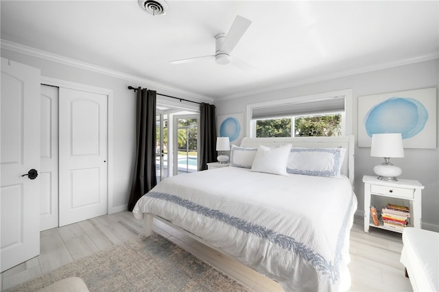 bedroom featuring visible vents, light wood-type flooring, and crown molding