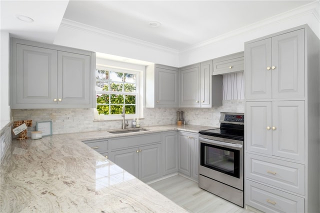 kitchen with gray cabinetry, crown molding, decorative backsplash, electric stove, and a sink