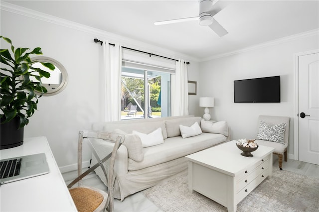 living area featuring a ceiling fan, baseboards, and ornamental molding